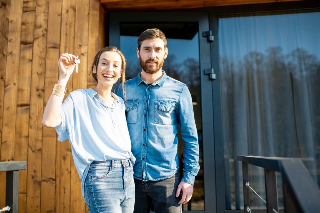 Glückliches Paar mit Hausschlüssel nach erfolgreicher Finanzierung in Glückstadt und Umgebung